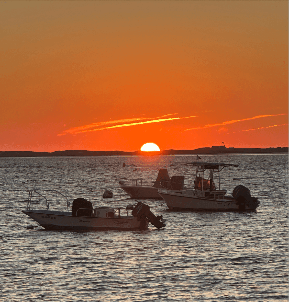 Sunset over a Nantucket harbor with boats at anchor
