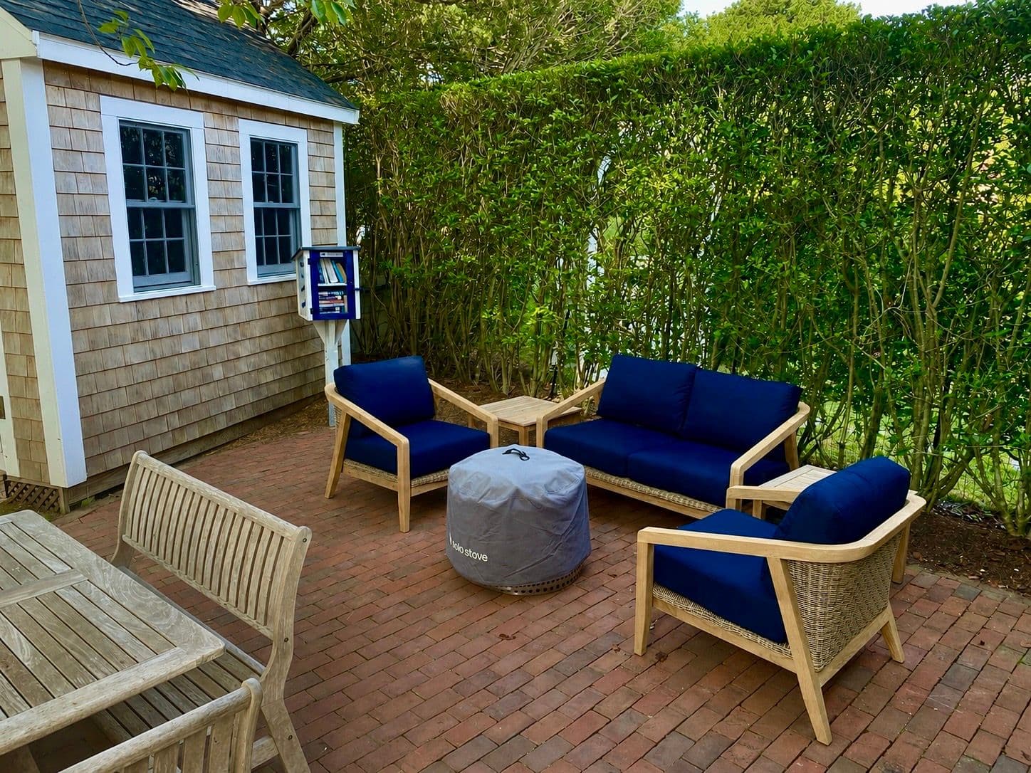 Brick patio with navy seating and a Solo Stove fire pit