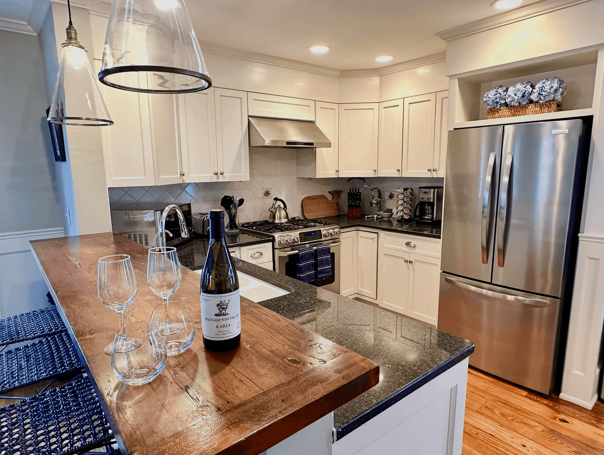 Kitchen breakfast bar with wine glasses and a whale cutting board
