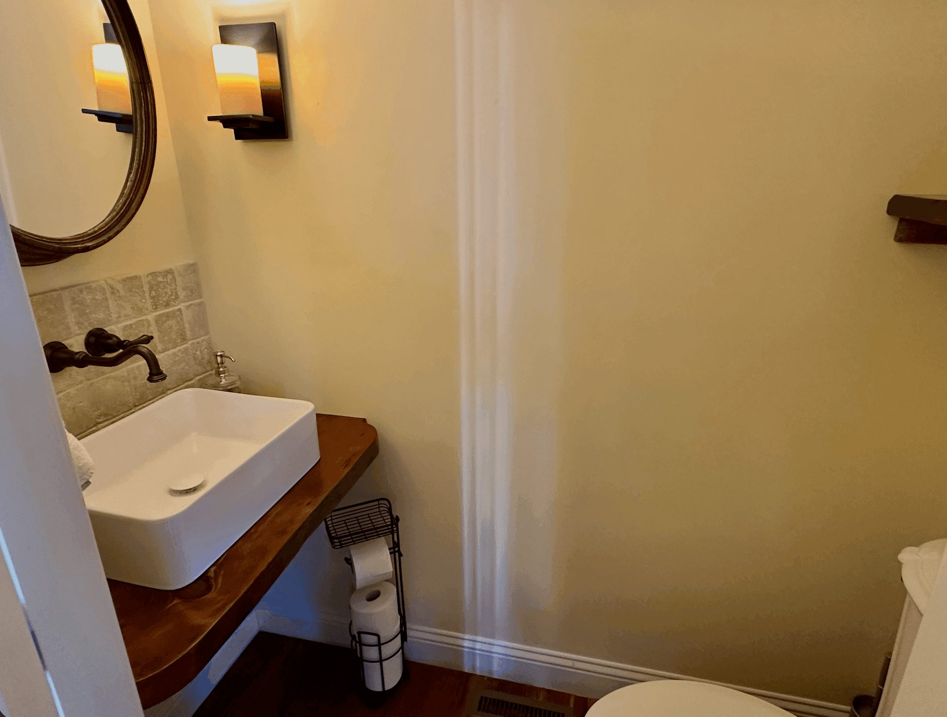 Powder room with a wood vanity and vessel sink