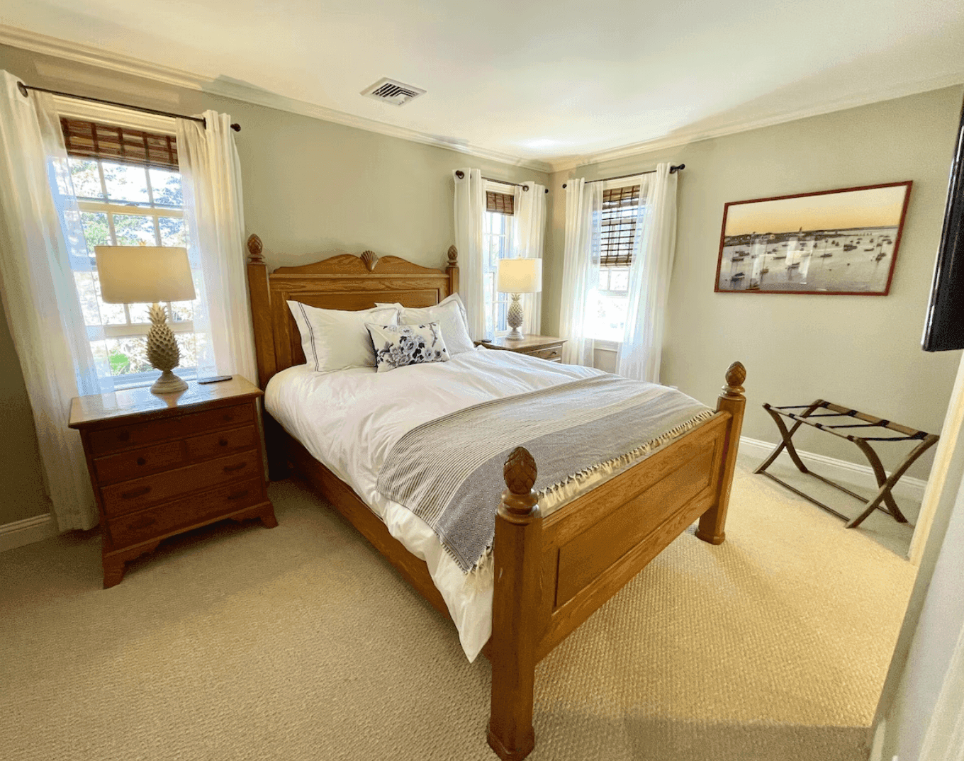 Bedroom with a pineapple-post bed and harbor painting
